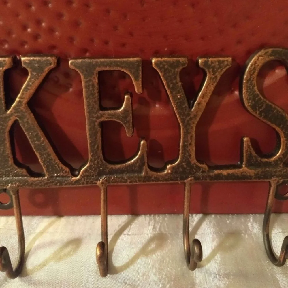 Metal Wall Mounted Key Rack With A Beautiful Black And Bronze Finish.